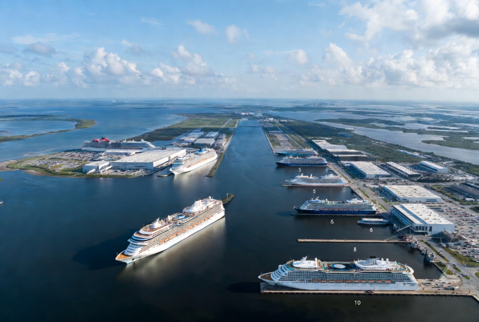 Aerial view of Port Canaveral with multiple cruise ships docked across the five terminals